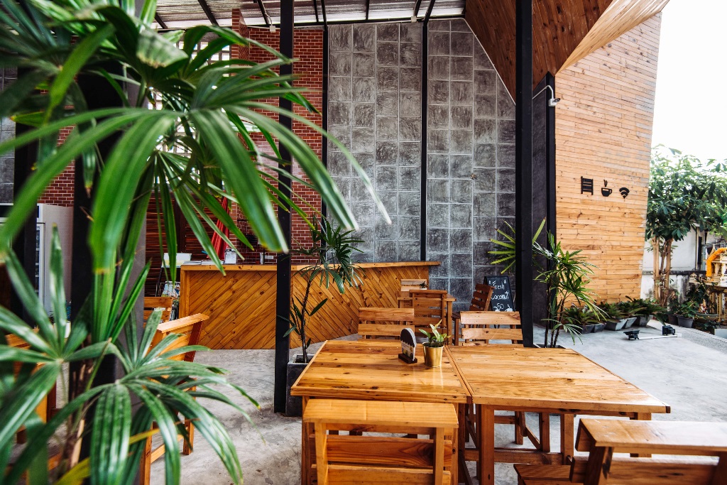 wooden table and chairs in a room with a plant